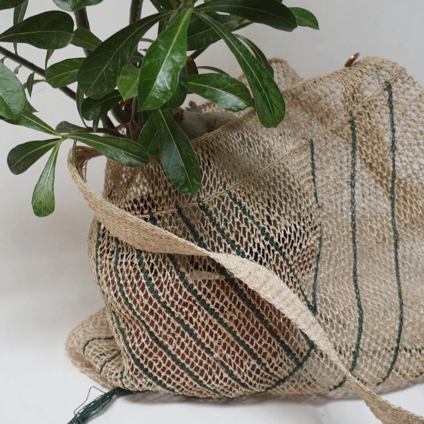 Bolso Kudzu en color natural con rayas en verde. Asa larga de una sola fibra. se puede llevar de bandolera. Cada Bolso esta hecho a mano y no hay dos bolsos exactamente iguales. Lleva una bolsa interior de lino.  100% natural kudzu vid  Medida: Ancho 38 cm. Alto 30 cm. Asa 115 cm  Hecho a mano en Laos