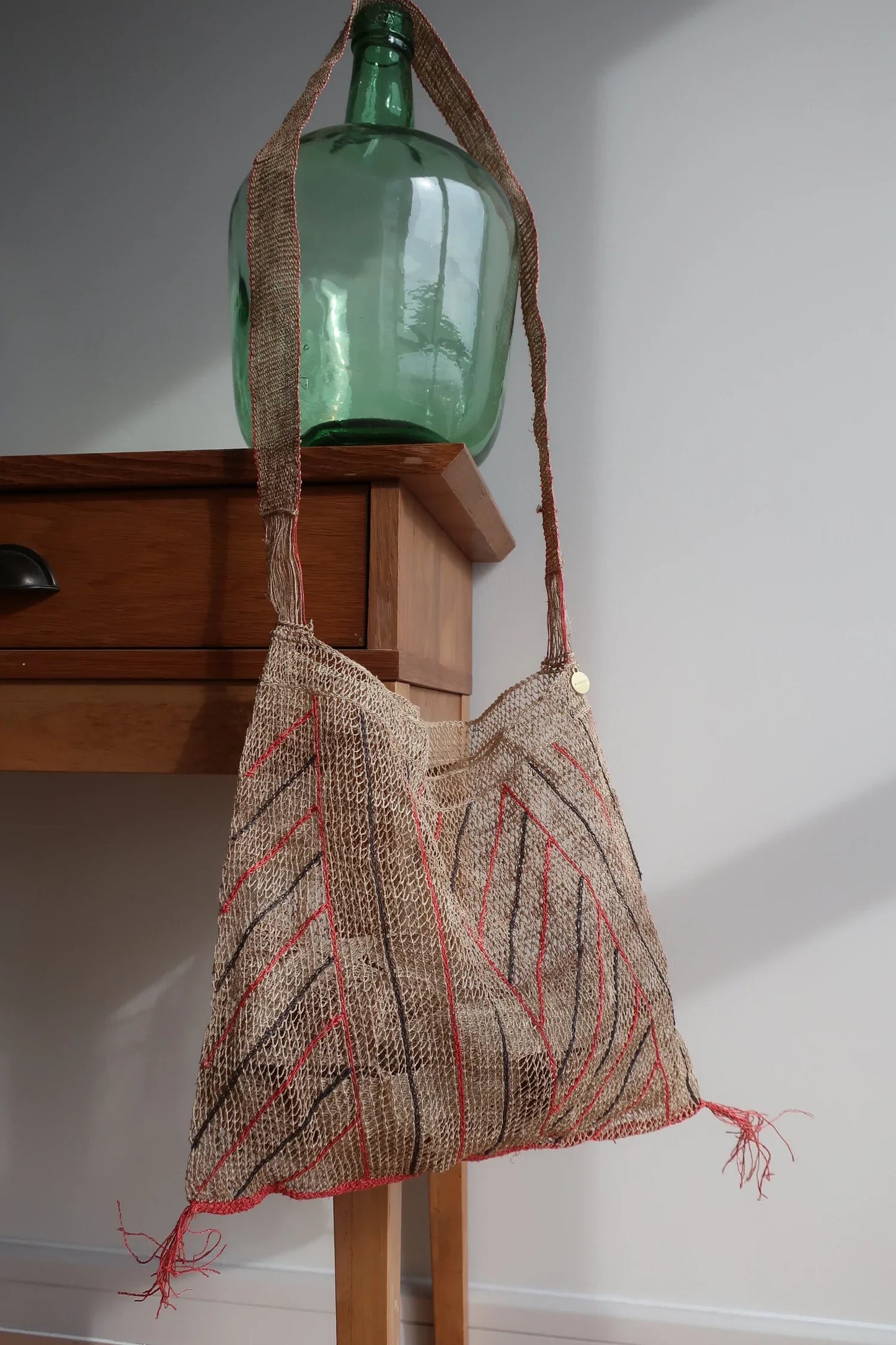 Bolso Kudzu en color natural con rayas en rojo y negro. Asa larga de una sola fibra. se puede llevar de bandolera. Cada Bolso esta hecho a mano y no hay dos bolsos exactamente iguales. Lleva una bolsa interior de lino.  100% natural kudzu vid  Medida: Ancho 38 cm. Alto 30 cm. Asa 115 cm  Hecho a mano en Laos